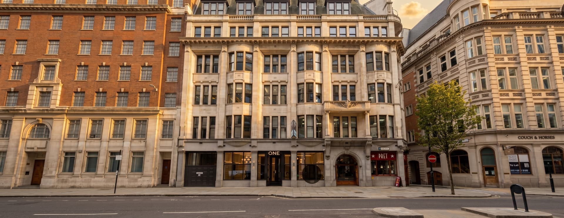 Stone and brick frontage of 1 Great Tower Street, London EC3, at golden hour